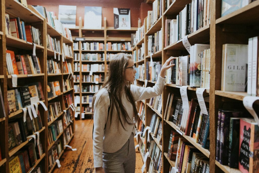 girl picking out a book in the library